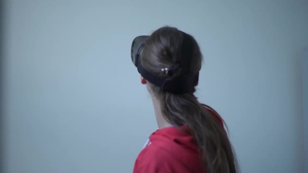 Chica joven probando un casco de realidad virtual y sonriendo — Vídeo de stock