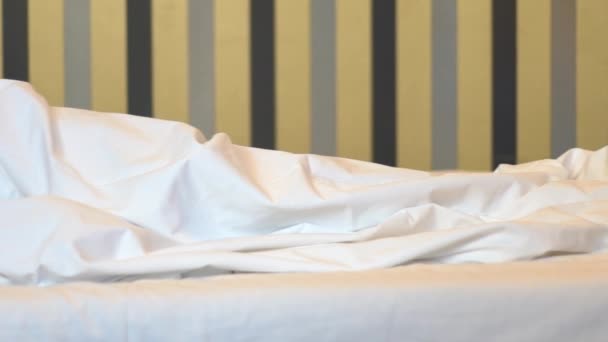 Junger Mann schläft auf bequemem Bett in Zeitlupe — Stockvideo