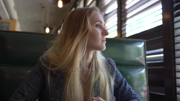 4K hermosa chica sentada en el café usando el teléfono móvil — Vídeos de Stock