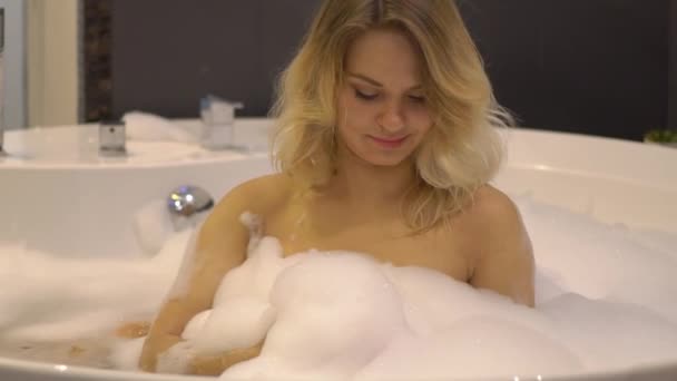 Vrouw nemen A bad en blazen op schuim In haar badkamer Slow Motion — Stockvideo