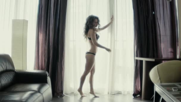 Chica bailando cerca de la ventana de cámara lenta — Vídeo de stock