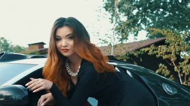 Ağır çekim güzel kız oturdu A siyah Cabrio spor araba ve flört