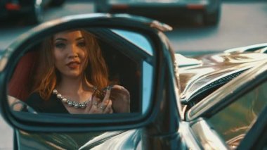 Ağır çekim güzel kız oturdu A siyah Cabrio spor araba ve flört