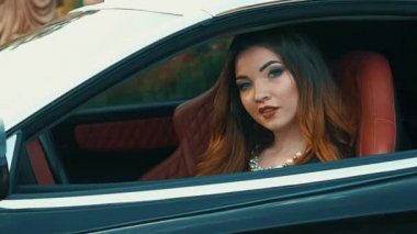 Ağır çekim güzel kız oturdu A siyah Cabrio spor araba ve flört