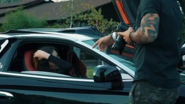 Ağır çekim güzel kız oturdu A siyah Cabrio spor araba ve flört