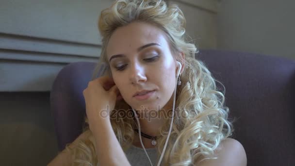 の悲しい少女カフェで携帯電話で音楽を聴く — ストック動画