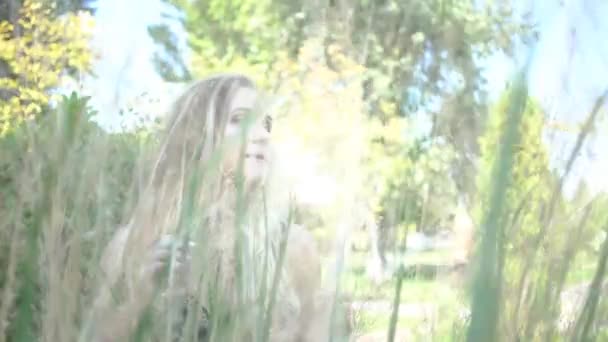 妇女躲在树叶后面的夏季公园 — 图库视频影像