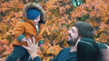 Gerçek zamanlı genç aile eğleniyor sonbahar Park'ta küçük çocuklarla