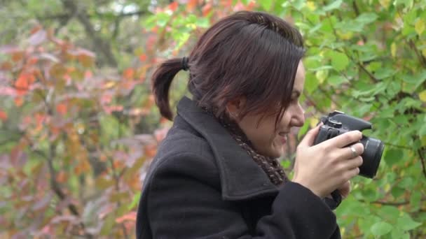 スロー モーション カメラで女の子が秋の森の写真を撮る — ストック動画