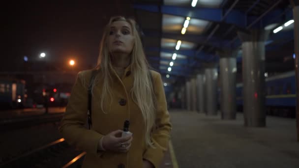 Ξανθιά Γυναίκα Που Καπνίζει Ηλεκτρονικό Τσιγάρο Στο Ένα Stationfilename Σιδηροδρόμων — Αρχείο Βίντεο