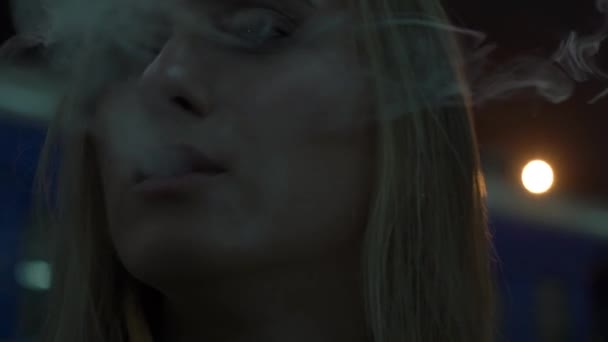 En temps réel la fille allume et fume une cigarette 