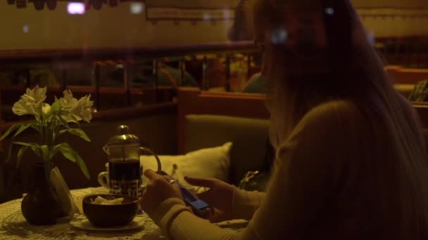 慢动作美丽的女孩坐在咖啡馆使用手机 — 图库视频影像