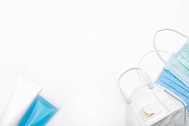 Beyaz arka planda koronavirüs önleyici önlemler için antibakteriyel sabun ve tıbbi maske..