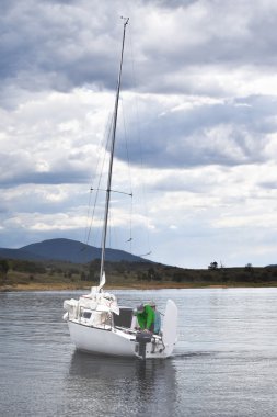 Bir göl kıyısında tarafından demirlemiş White Yat. Dağ uzakta.
