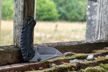 Bükülmüş pozisyonda küçük bir çakı. Bıçak yarı katlanmış bir pozisyonda..