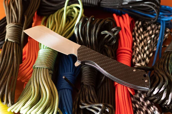 Taschenmesser und bunte Seile. Klappmesser und Paracord. — Stockfoto