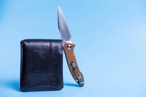 Fickkniv och mens plånbok. Blå bakgrund. — Stockfoto