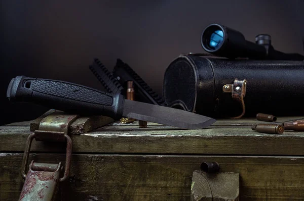 Cuchillo y mira. Un cuchillo grande y una vista de caza en una caja de guerra  .. — Foto de Stock