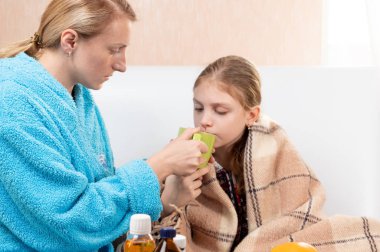 Anne bebeğe çay verir. Annem hasta bir çocuğa çay verir. Kızı hastalandı..