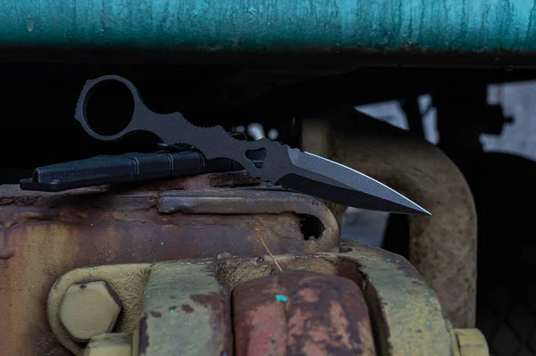 Coltello in metallo nero per l'esercito. Coltello militare su un'auto militare . — Foto Stock