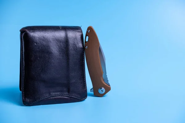 The knife is folded and a purse. Light blue background. — Zdjęcie stockowe