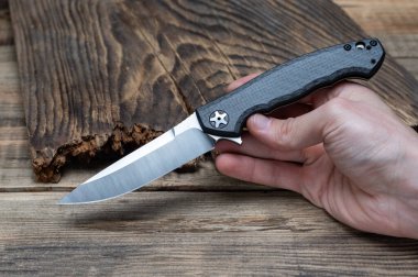 Bir elde katlanan bıçak. Bir adam bıçağı tutar ve gösterir. Bıçak reklamı..