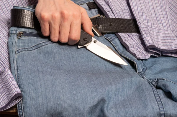 Bıçak ve el. Sıradan kıyafetler ve elinde bir bıçak. Erkek gardırobu. Üst.