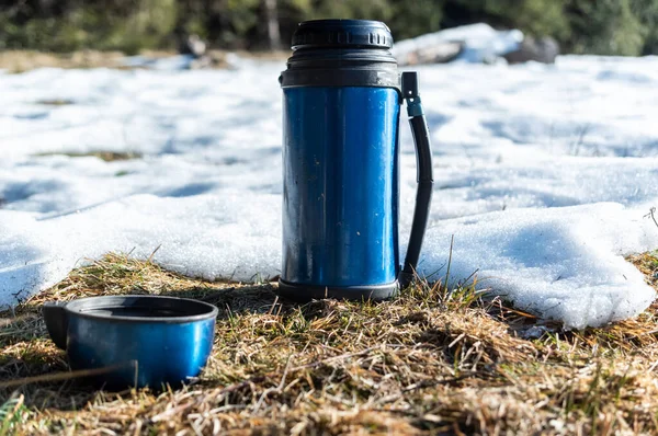 Thermos camping. Thermos for tourism. Thermos in nature. Thermos and mug.