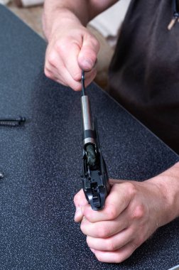 Silah temizliği. Namluyu temizliyorum. Silah ellerde. Dikey çerçeve.