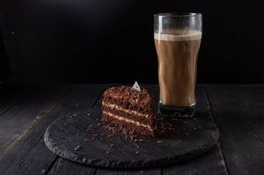 Çikolatalı kek ve tepside latte. Çikolatalı kahveli kek ve sütlü kahve. Alçak tuş.