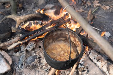 Ormanda ateş yakmak. Doğada kamp ateşinde yulaf lapası pişirmek. Üst.