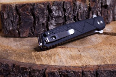 Katlanmış pozisyonda katlanmış çakı. Ahşap bir yüzeyde katlanmış bir bıçak..