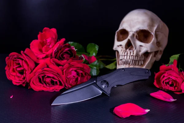 Schwarzes Klappmesser Auf Rotem Rosen Hintergrund Und Totenkopf — Stockfoto