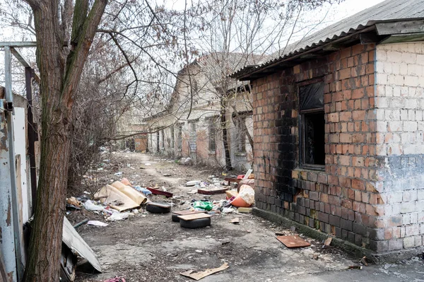 Een oud bakstenen gebouw met een vuur. Industrieel bakstenen gebouw. Vuil gebouw en vuilnis op straat. — Stockfoto