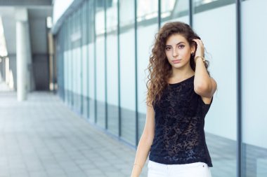 Sokakta duran, saç tutan kıvırcık üzgün kız