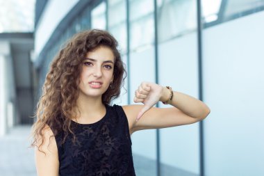 Başparmak aşağı, negatif duygular, açık havada gösterilen güzel kıvırcık kız