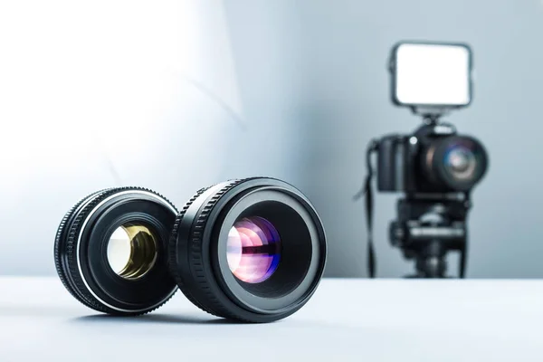 スタジオ、デジタル一眼レフ カメラは、光とソフト ボックスの背景の白いテーブルの上の 2 つのレンズ. — ストック写真