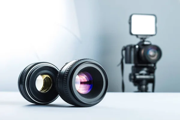 Två linser på ett vitt bord i Studio, mot bakgrund av Dslr kameran ljus och softbox. — Stockfoto