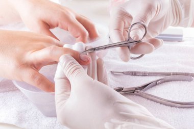 Teknisyen Müşteri bir manikür, tırnak salonu veren tırnak. Genç Kafkas kadın Fransız manikür alma. Tırnak manikür vermek kütikül itici kullanan bir kadın portre çekim.