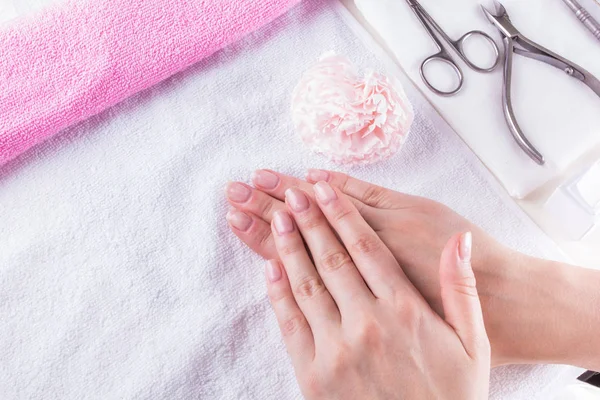 Close-up shot van vrouwelijke handen met french manicure op een handdoek, manicure set. — Stockfoto