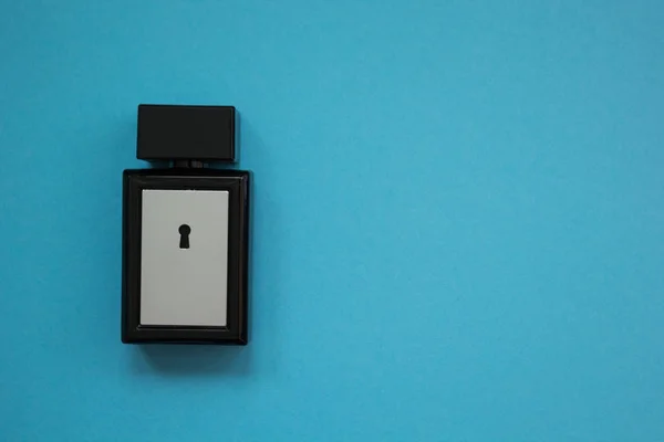 Egy négyzet alakú üveg parfüm, kék háttérrel. — Stock Fotó