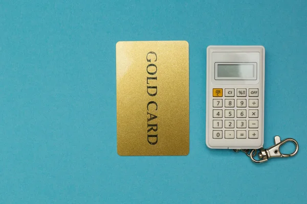 Tarjeta de crédito sobre fondo calculadora sobre fondo azul . — Foto de Stock