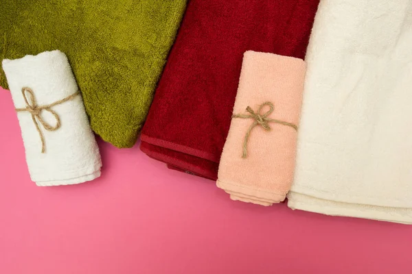 Multi-colored towels on a pink background — Stock Photo, Image