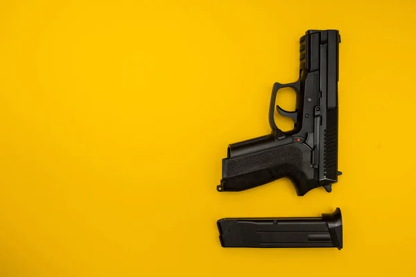 Svart pistol på gul bakgrund — Stockfoto