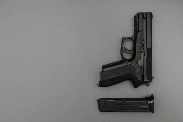 Black metal 9mm pistol and magazine on grey background — Stock Photo, Image