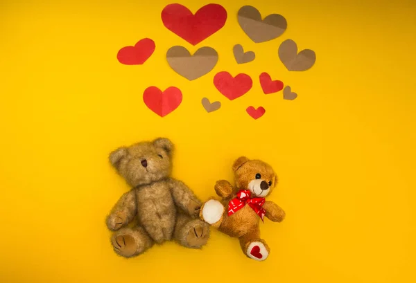 Two teddy bears on a yellow background and heart over them — Stock Photo, Image