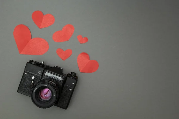 Schwarze Retro-Kamera auf schwarzem Hintergrund und rotem Herz. — Stockfoto