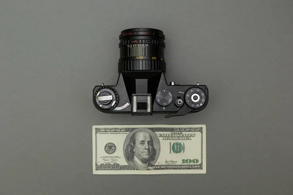 Černé retro fotoaparát a sto dolarů na šedém pozadí — Stock fotografie
