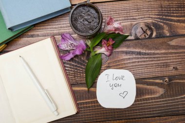 Not Defteri, çiçekler ve ahşap bir masa üzerinde fırçalayın. 