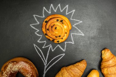 Bir çiçek şeklinde siyah bir zemin üzerine taze pişmiş mal.